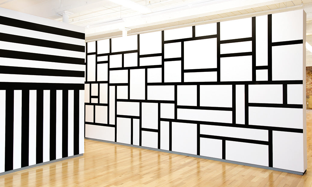 Sol LeWitt (B. 1928, Hartford Connecticut)
Wall Drawing 630, January 1990 (left):
A wall is divided horizontally into two equal parts. Top: alternating horizontal black and white 8-inch (20 cm) bands. Bottom: alternating vertical black and white 8-inch (20 cm) bands. India ink.
Wall Drawing 614, July 1989 (right): Rectangles formed by 3-inch (8 cm) wide India ink bands, meeting at right angles. India ink. On display in the exhibition Sol LeWitt: A Wall Drawing Retrospective