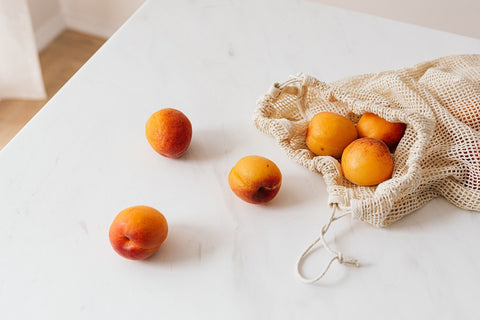 Reusable cotton produce bag with oranges