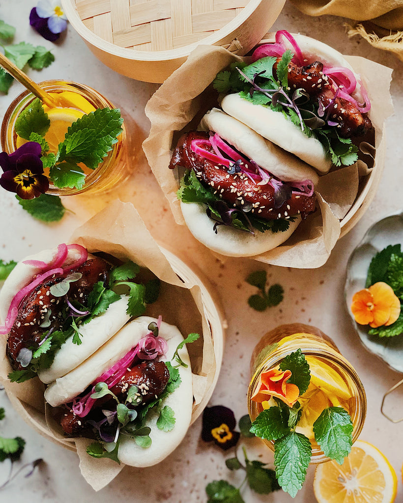 Roasted chicken thighs in sticky char siu marinade, and served tucked into these “lotus leaf” style steamed bao (less common in Cantonese cuisine) topped with pickled onions, cilantro, and radish microgreens.