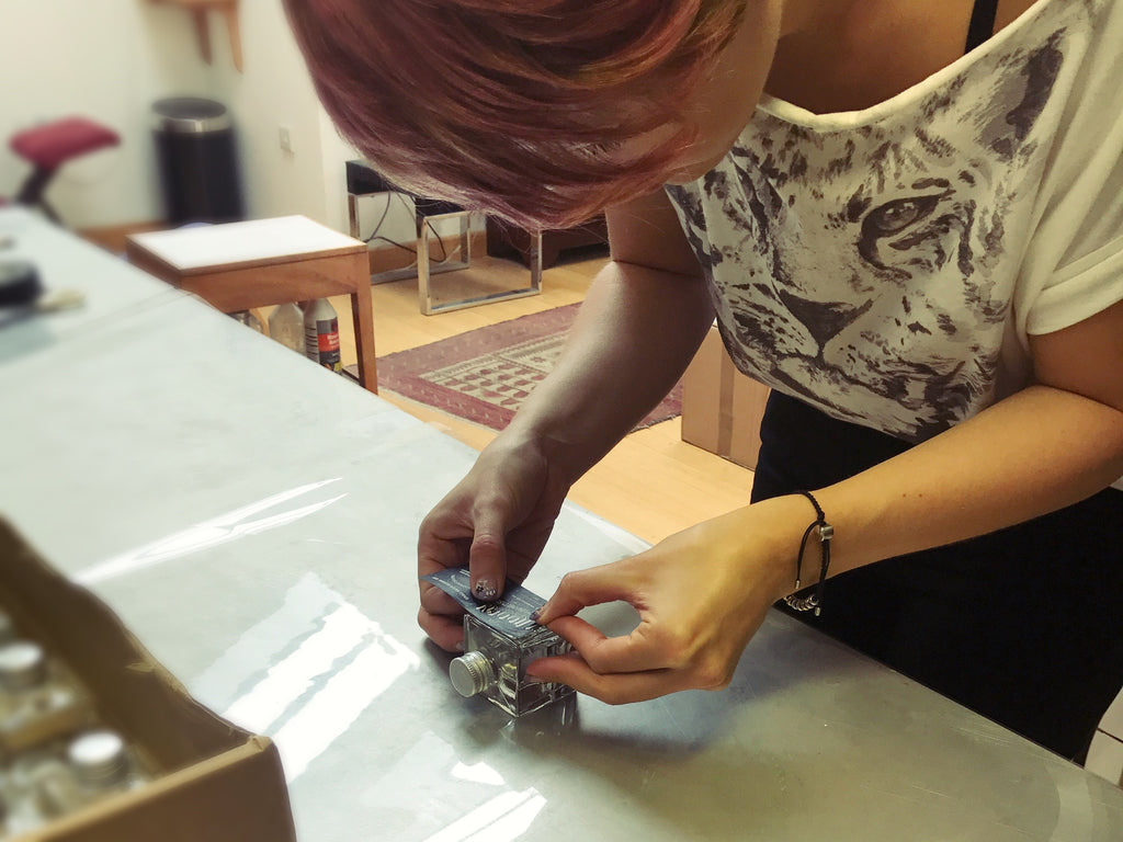 Jenny labelling miniature bottles of Hidden Curiosities gin