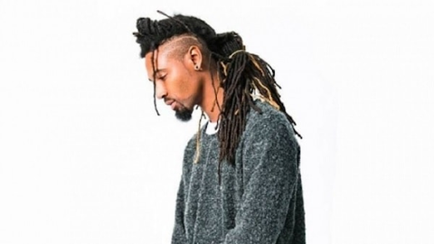 Young man with very long locs in a mohawk with exposed sides. 