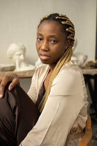 A model with dyed knotless braids looks into the camera.