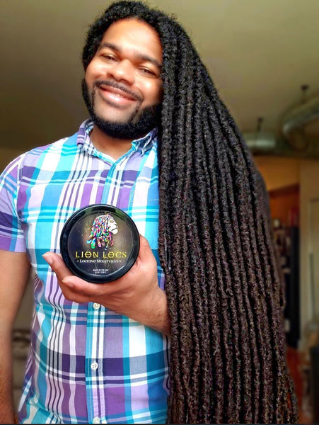a happy Lion Locs customer taking a picture with our loc moisturizer