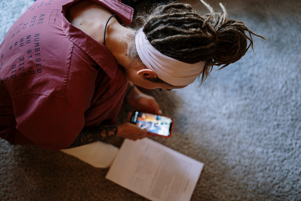 A woman with dreads typing on her phone