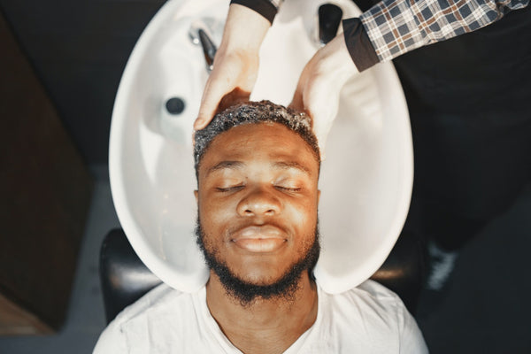 a man with dreadlocks washing his hair