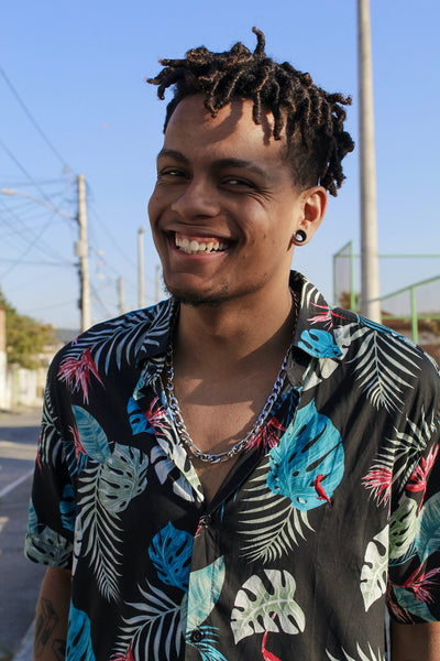 a smiling man with dreadlocks