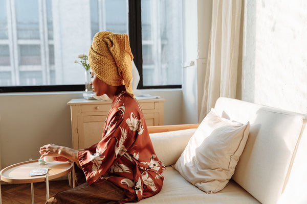 woman drying her dreadlocks with a microfiber towel