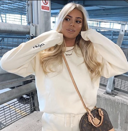 Influencer wearing our Ultimate Ukiyo cream tracksuit jogger set, coupled with a black and cream fabric handbag