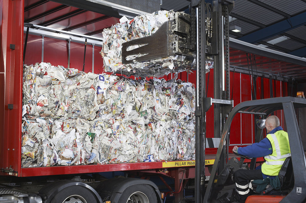 Forklift loading recycling paper onto truck
