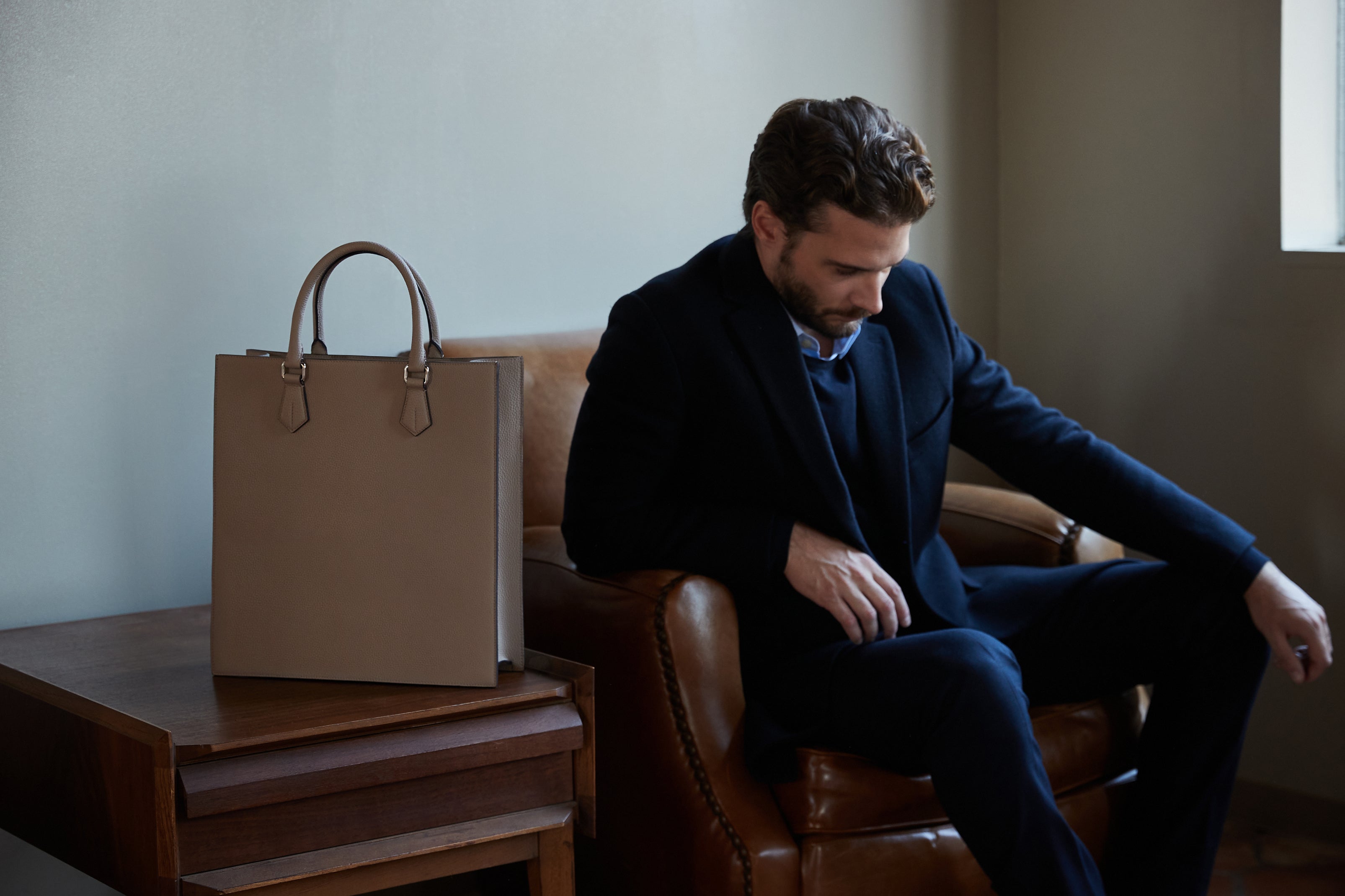 A businessman with a stylish men's bag made of full-grain leather.