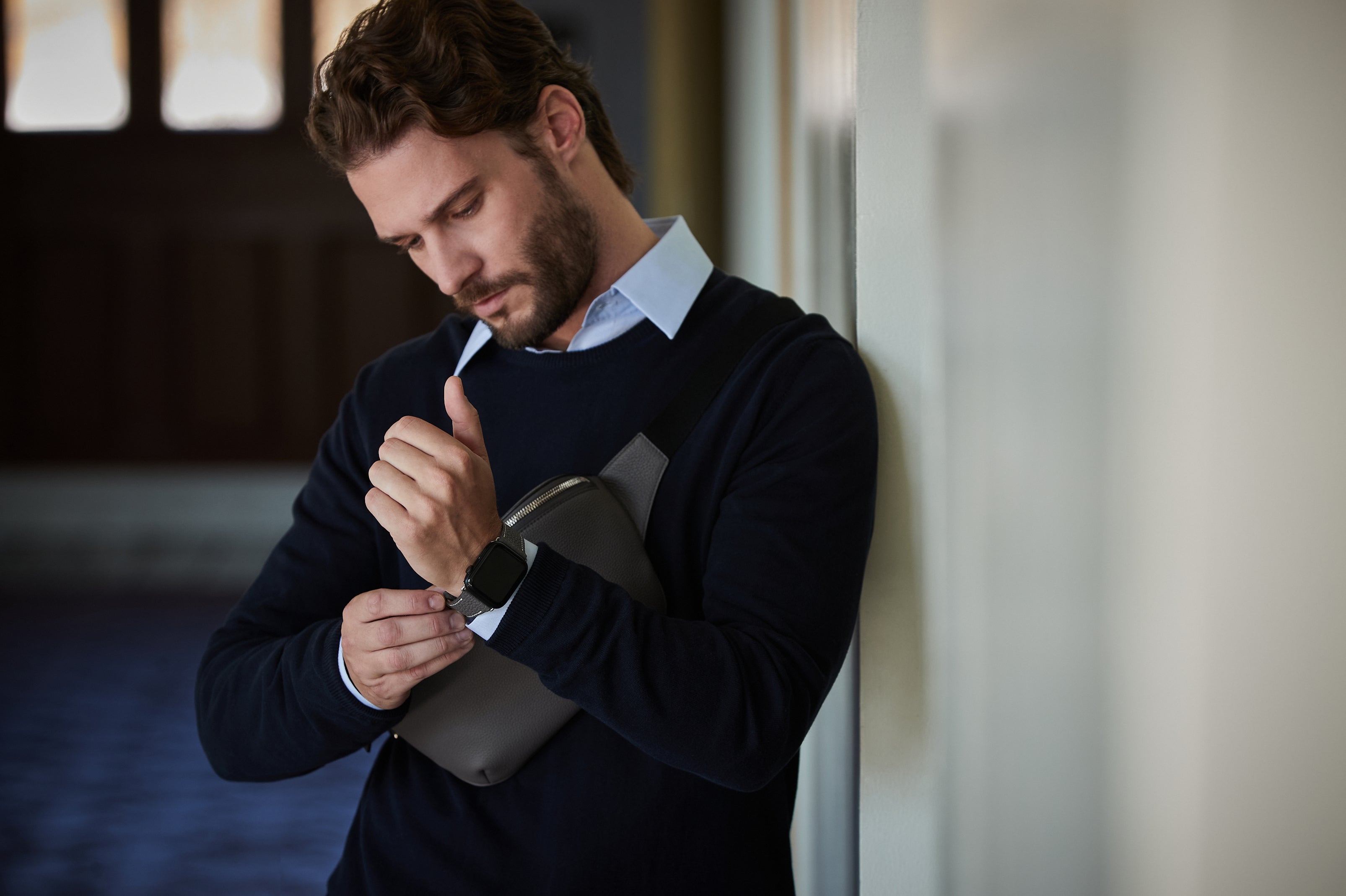 A businessman wears his Apple Watch with a high-quality leather strap.