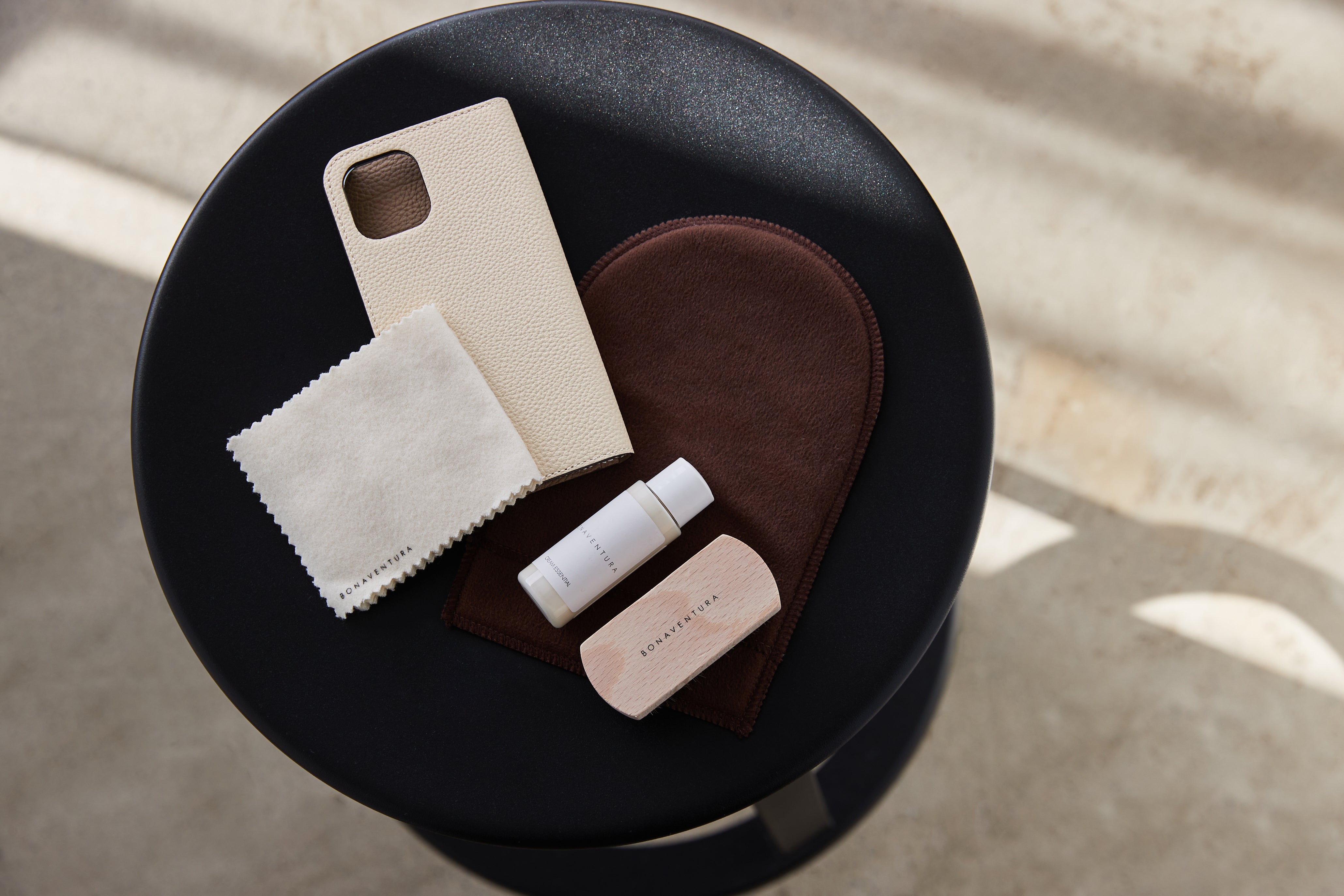 Various leather care products on an elegant wooden table, ready for use.