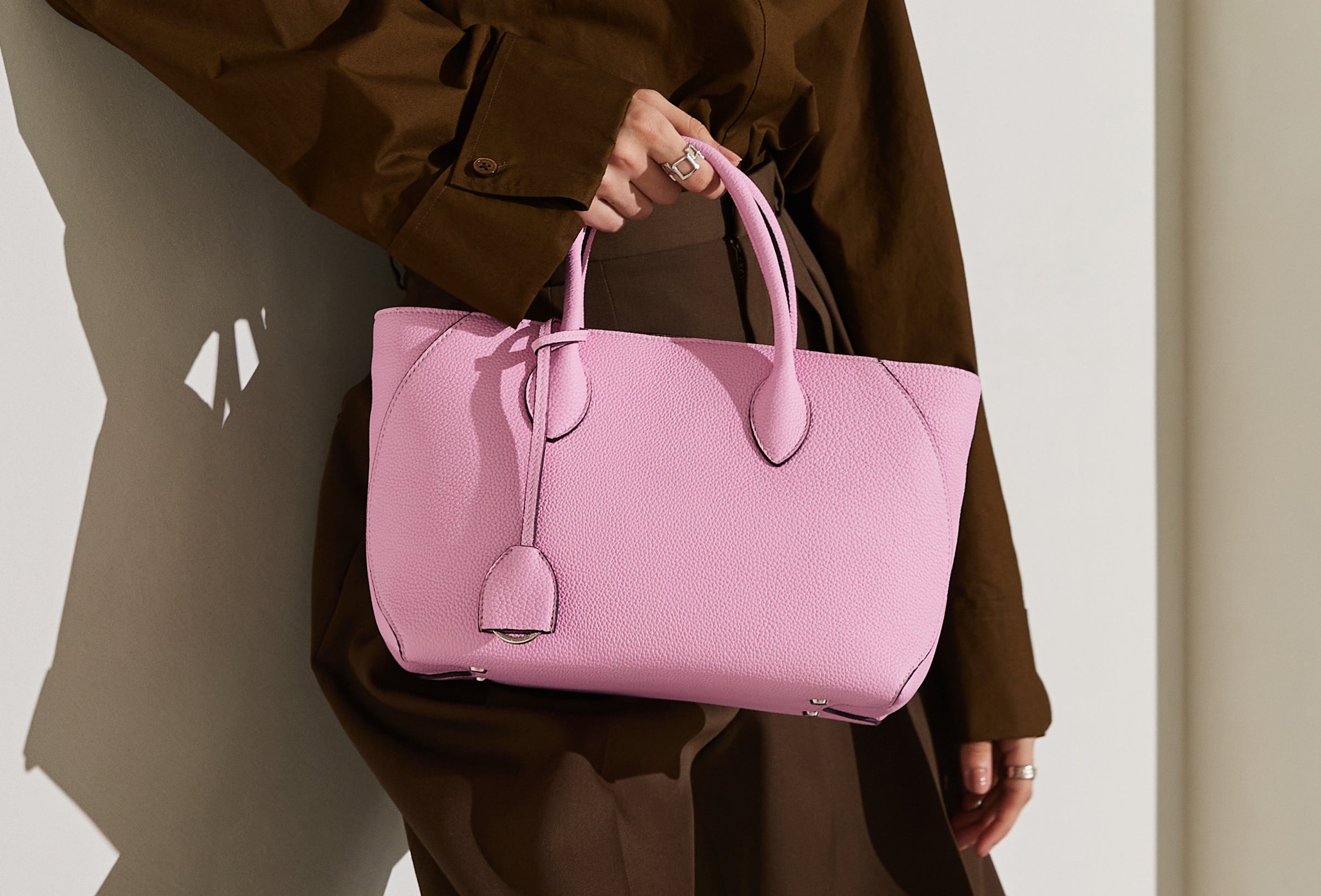 A stylish pink handbag made of genuine leather.