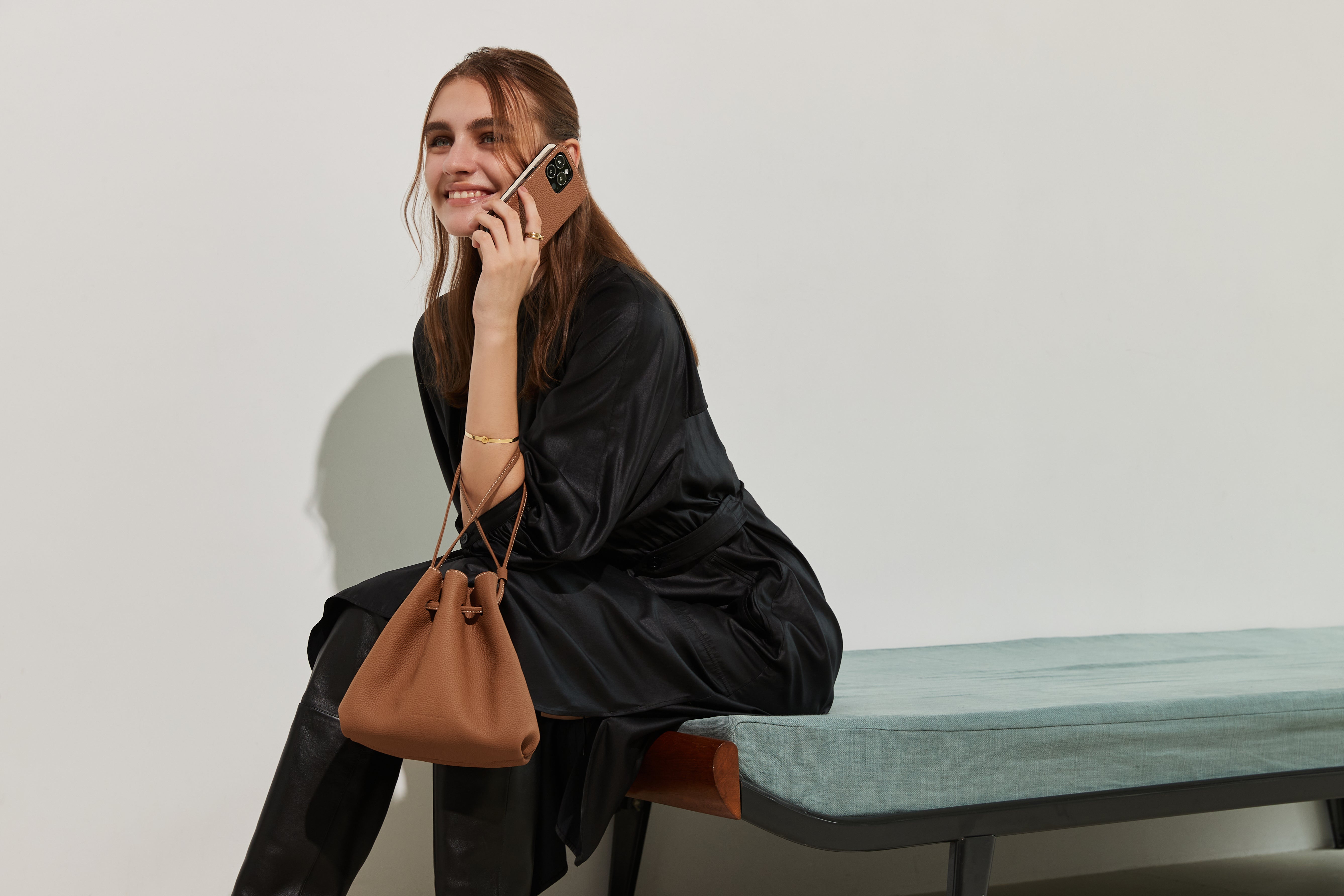 An elegant woman with a high-quality BONAVENTURA bag and a matching iPhone leather case.
