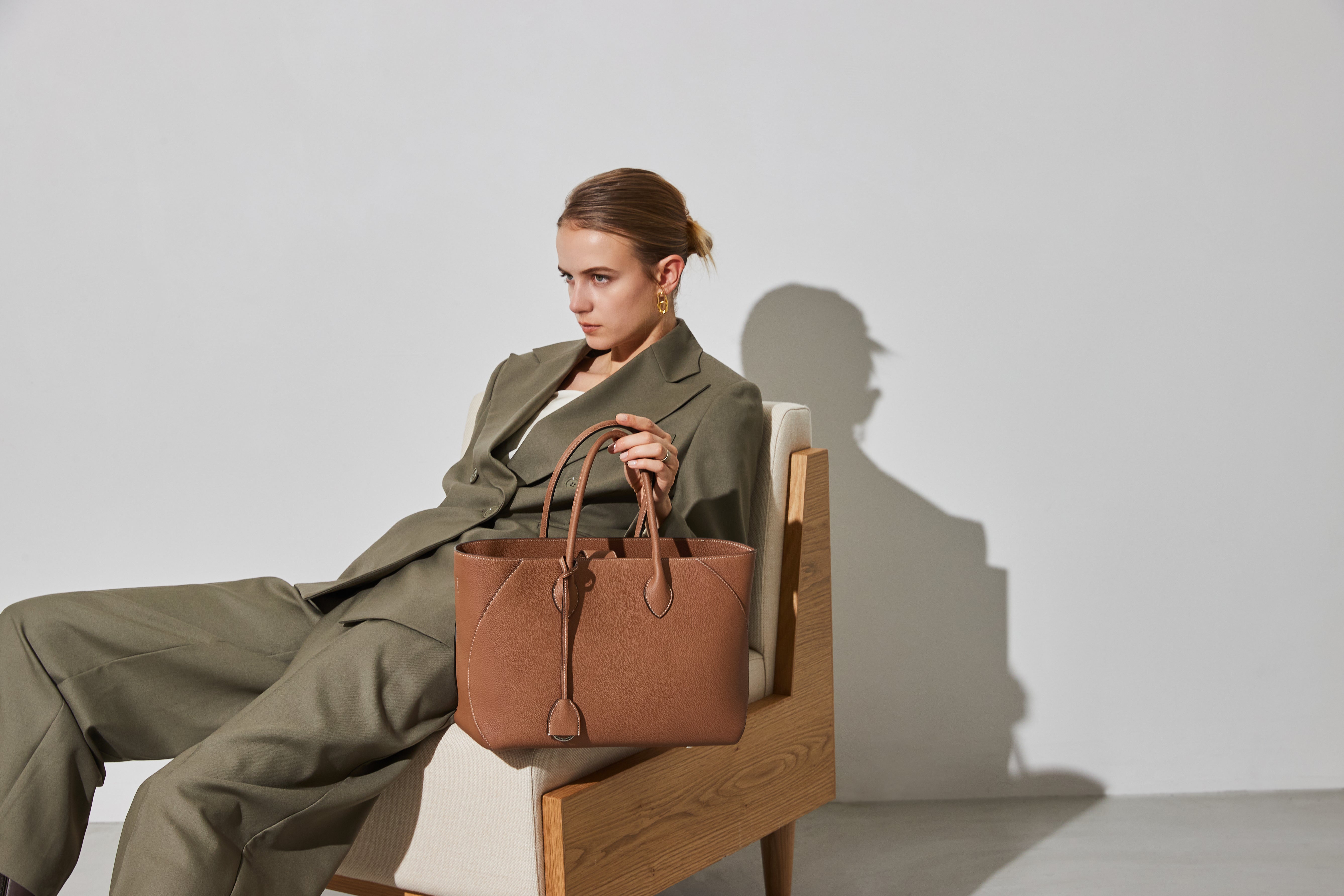 Stylish woman with an elegant leather bag in the office.