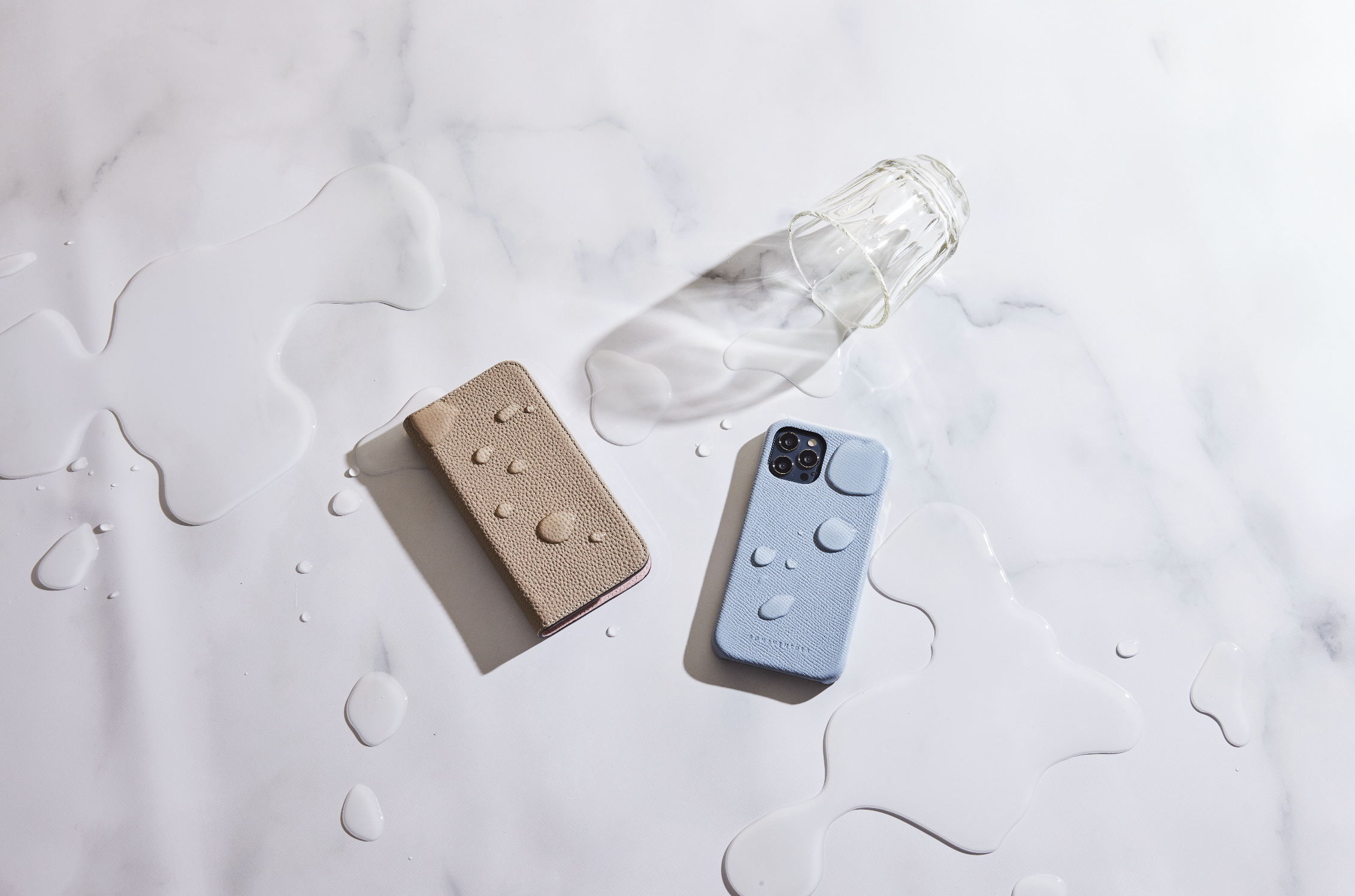 Two iPhones in BONAVENTURA cases that protect the device from water drops to highlight the case's protective function.