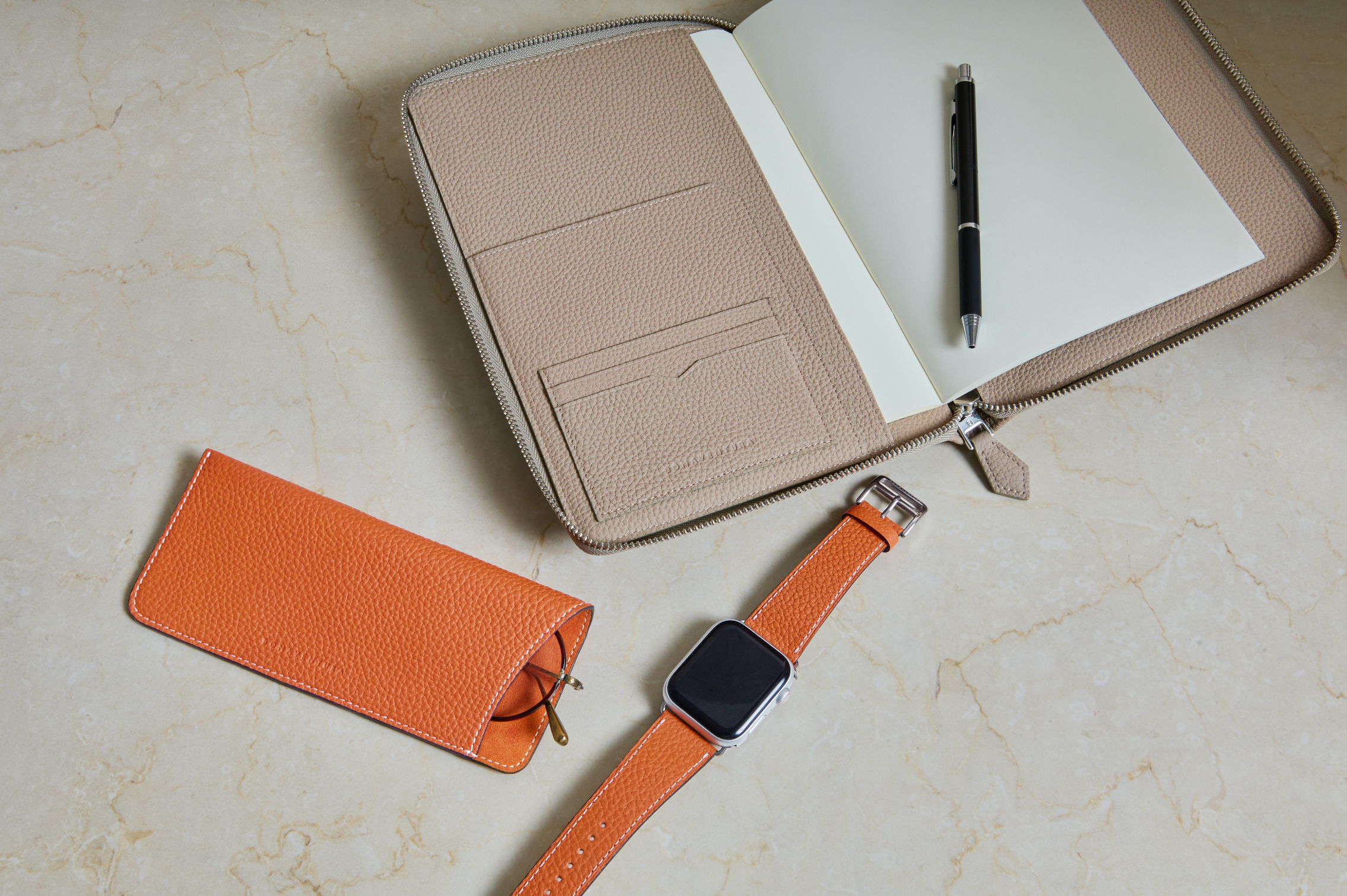 Vari accessori in pelle BONAVENTURA per gadget e riunioni di lavoro disposti con stile su una scrivania.
