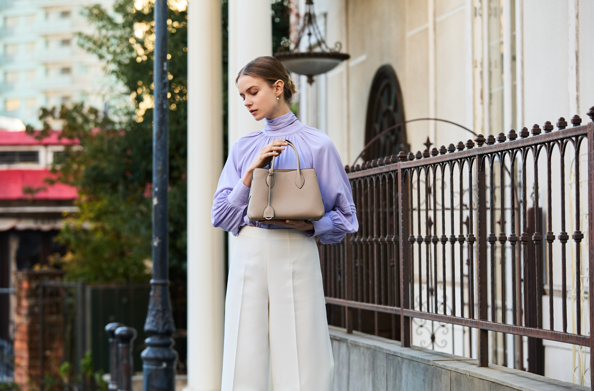 Eine stilvoll gekleidete Frau trägt in der Mode Metropole Mailand eine elegante und luxuriöse Handtasche aus feinstem Leder von BONAVENTURA.