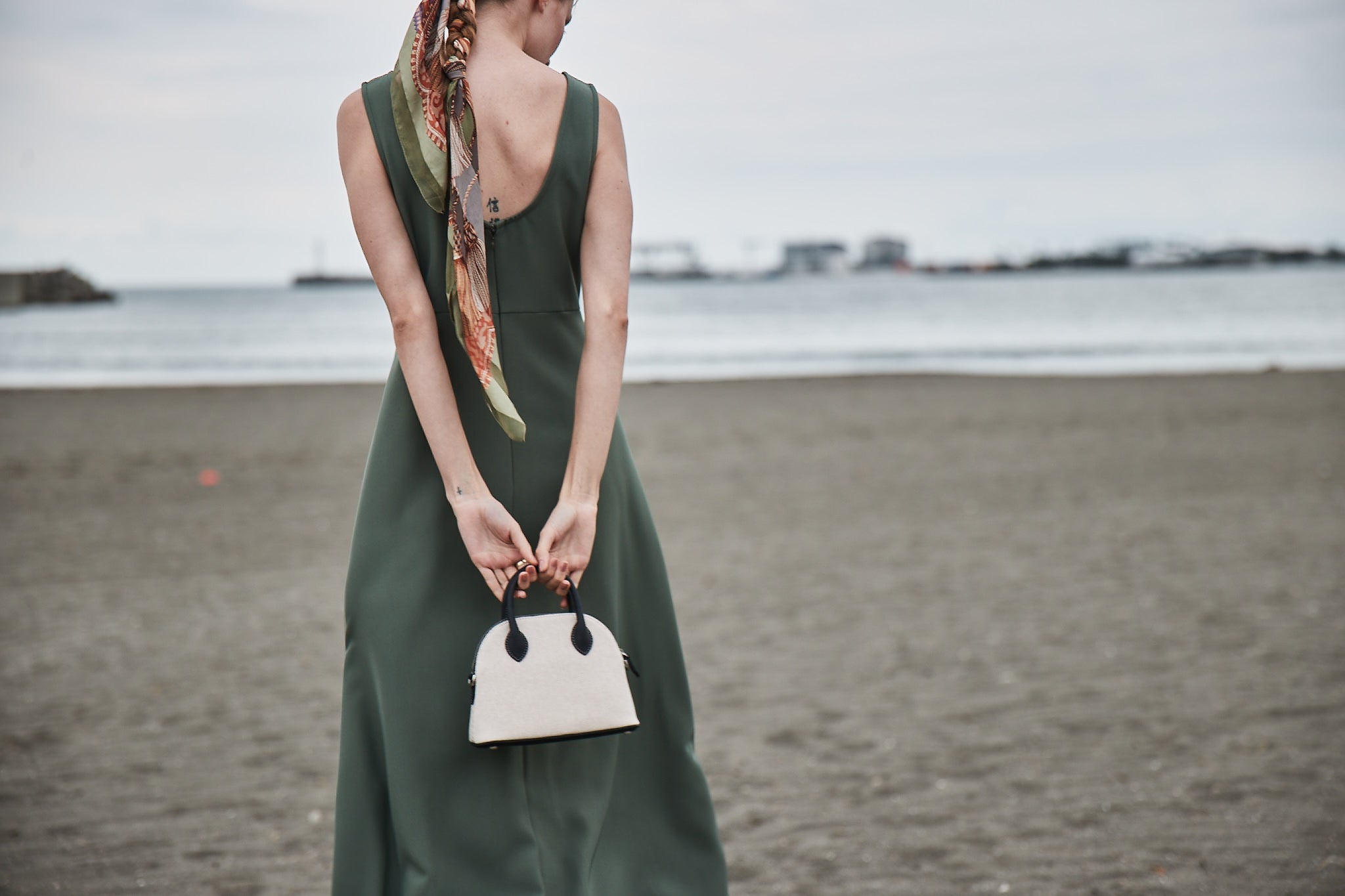 A stylish woman with a small beach bag, perfect for the evening.