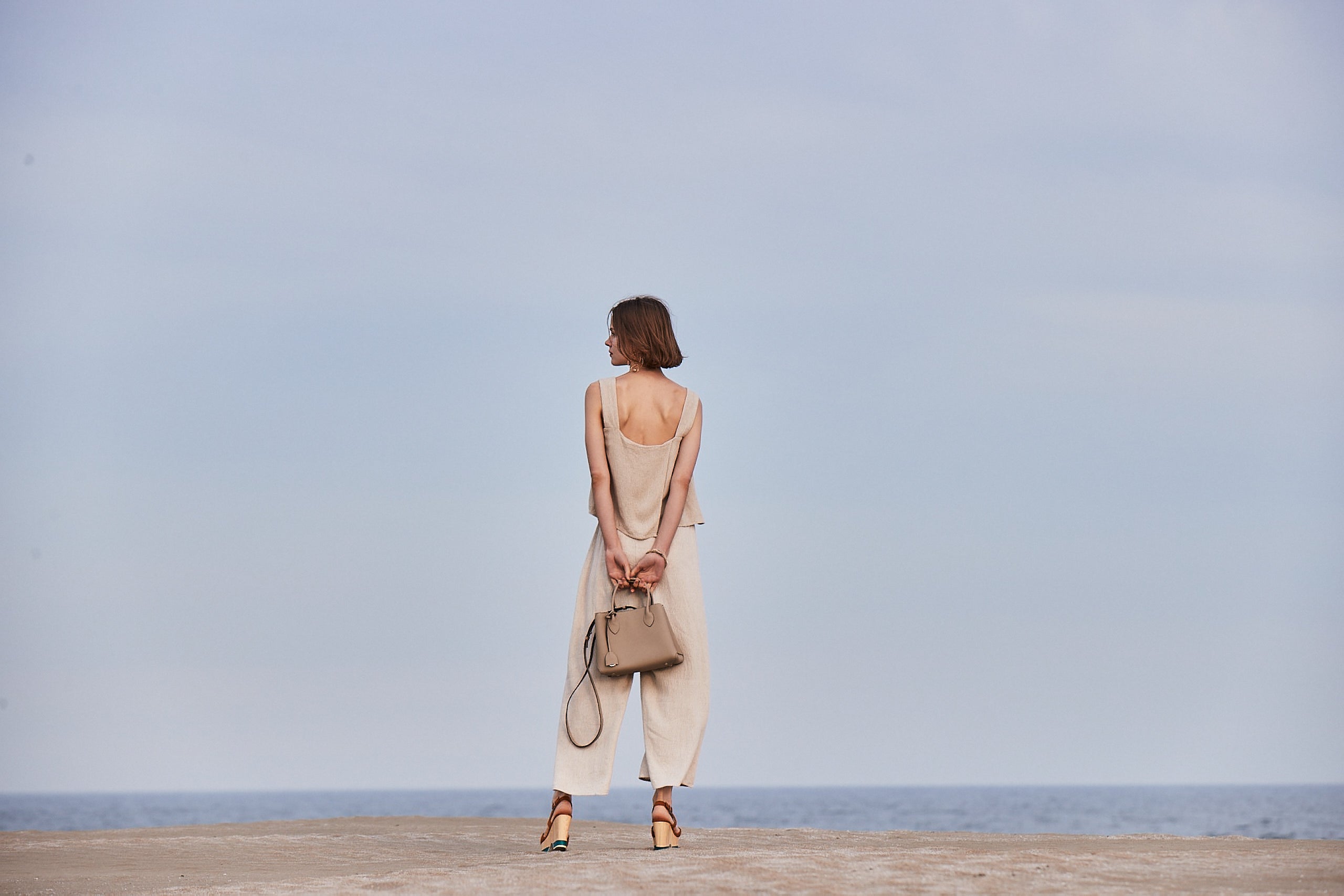 A woman on the beach with a sustainable BONAVENTURA bag.