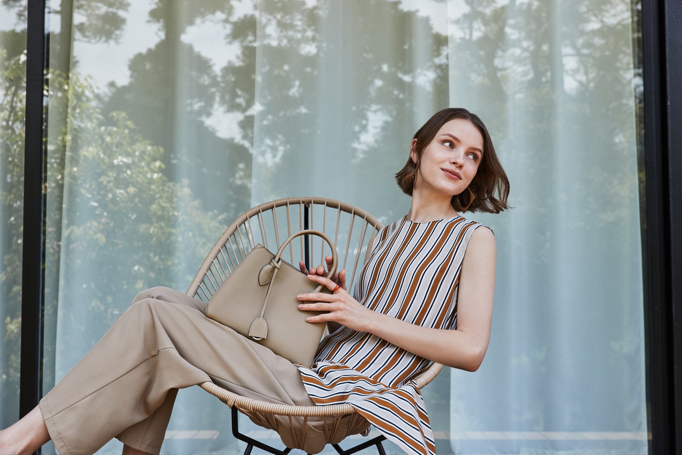 Elegante vrouw met haar Mia-tas in natuurlijke kleur greige van BONAVENTURA.