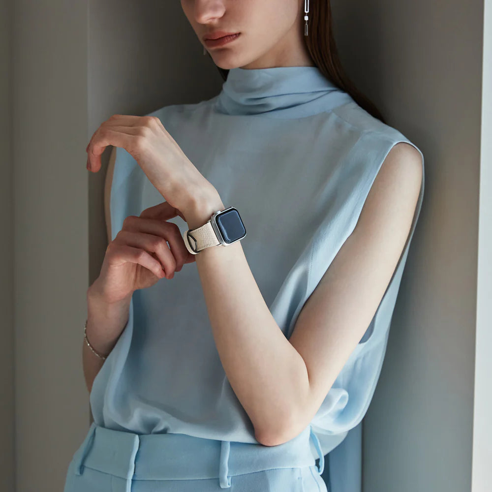 Elegante vrouw draagt bijpassende BONAVENTURA leren armband bij haar Apple Watch en outfit.