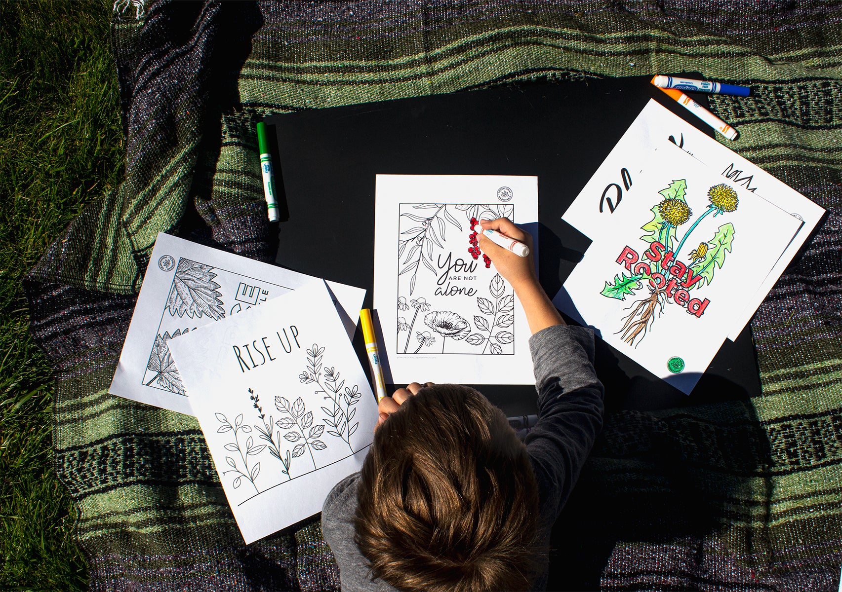 Child coloring in nature-inspired coloring book sheets />