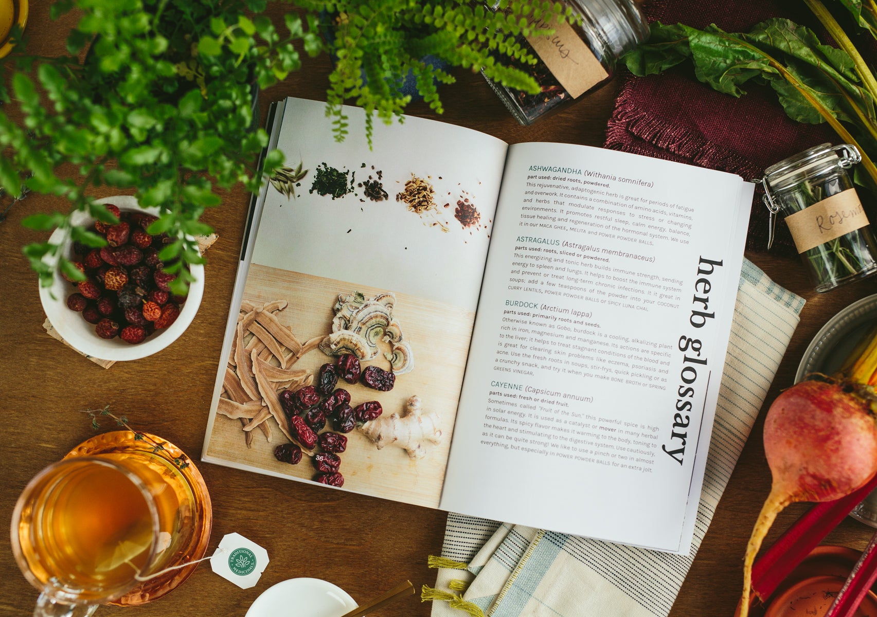 Herbal recipe book sitting on table next to herbal ingredients