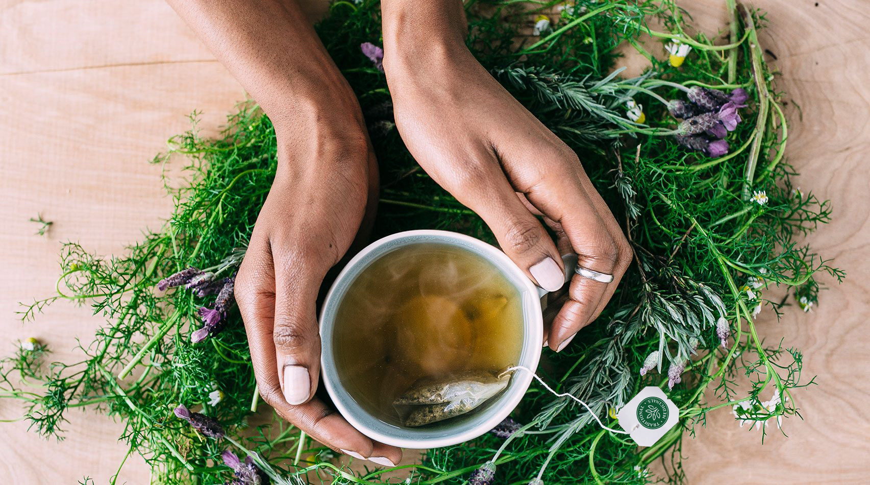 Organic Chamomile Lavender Tea Brewing in Cup being held in Hands