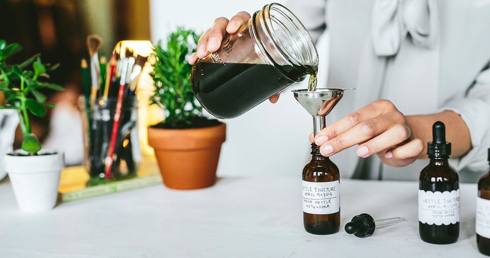 pouring nettle tincture into dosage bottle