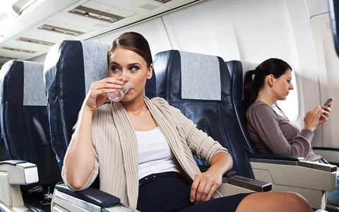 girl drinking on an airplane 