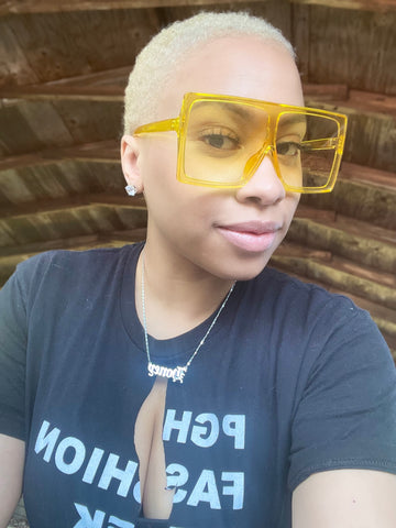 Light skin woman, black tshirt, yellow sunglasses, blonde hair
