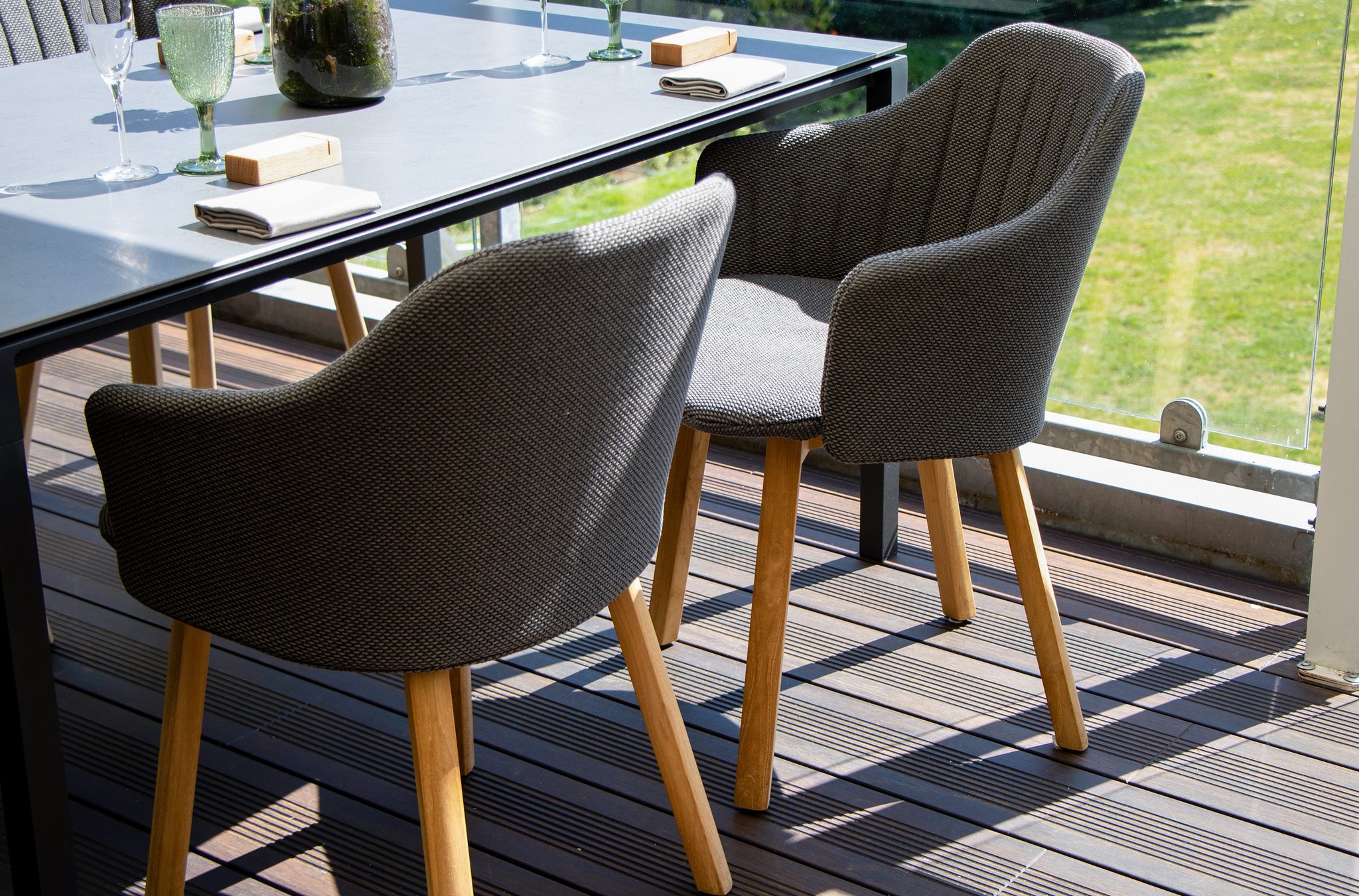 Close ups of two dark grey Cane-line dining chairs at Restaurant Buhlmann outdoor terrace