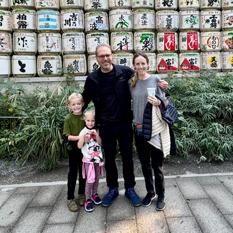 Family in Japan in front of old sake barrels