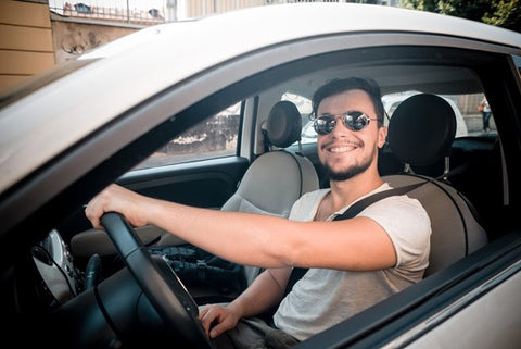 Can I Mix Kava and Alcohol? Young man smiling while looking out his rolled down car window. 