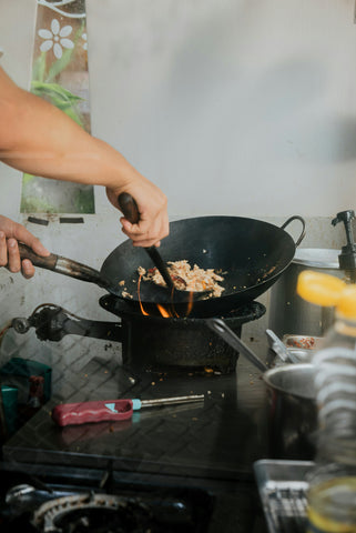Person cooking fried rice in wok
