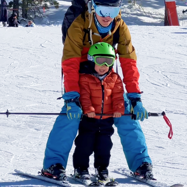 Skiing with your toddler in front of you using your poles as support