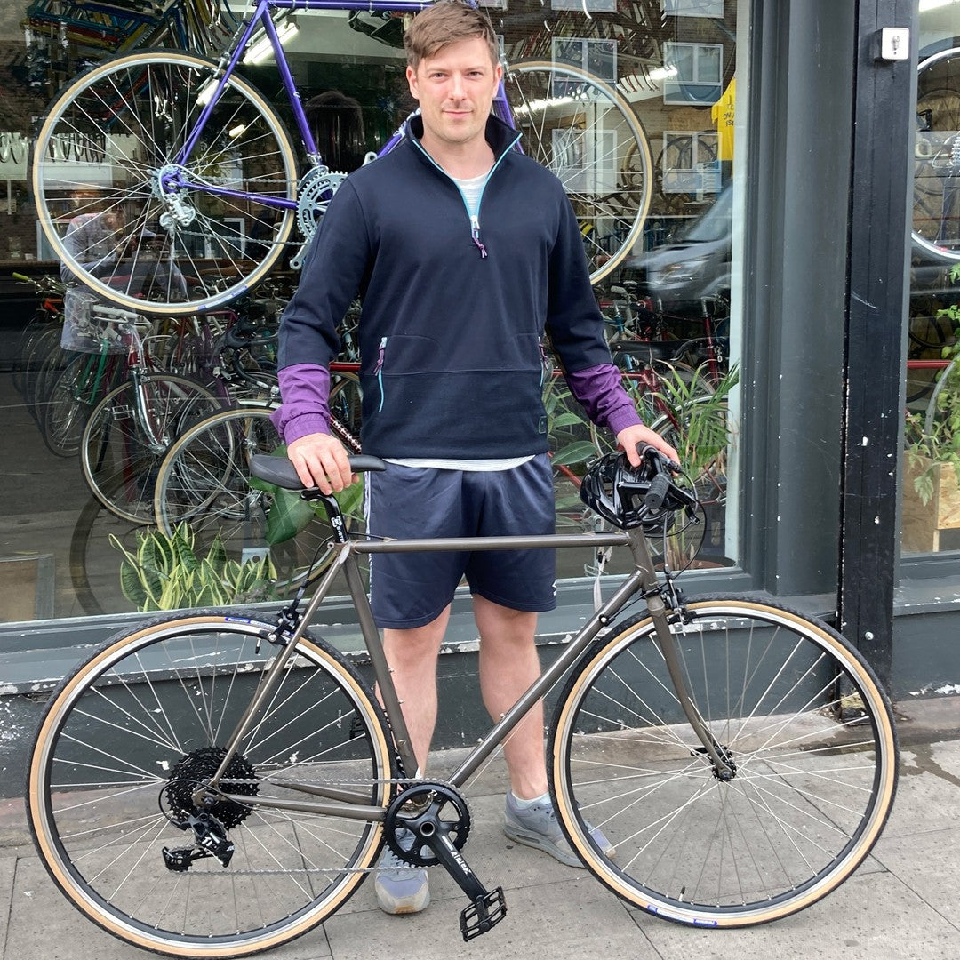 A customer with a custom built bicycle with a raw lacquer finish.