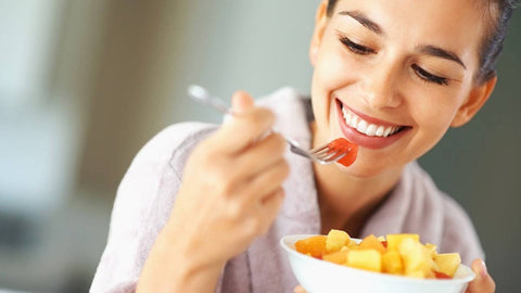 Mujer sonriendo mientras come