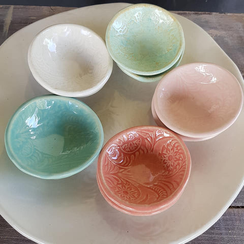Five small bowls in blue, red and green.