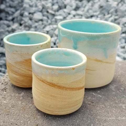 three pottery mugs without handles made by Chez Pottery