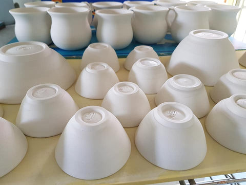 a table full of white pottery