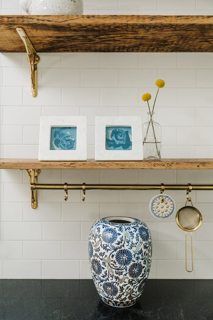 "Limestone Wall" and "Gneiss Wall" abstract paintings in marble frames styled on kitchen shelves above vintage chinoiserie vase