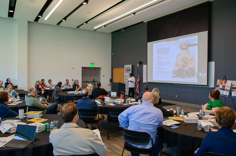 Wide shot of audience and chef at podium addressing audience