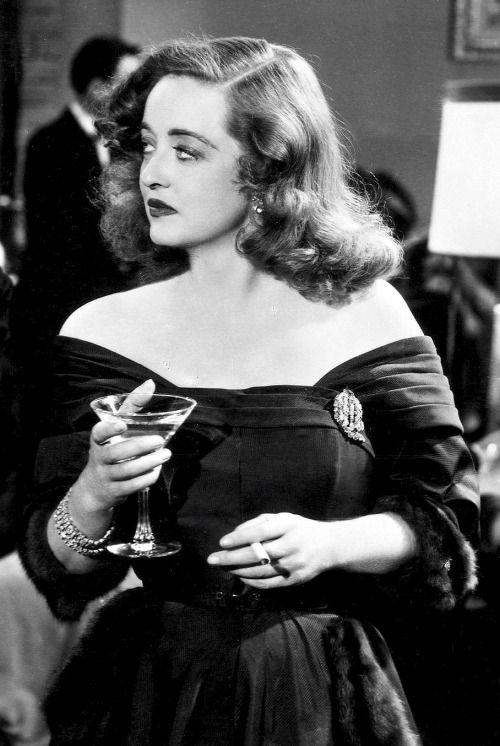 Bette Davis wearing a dark dress on set of All About Eve