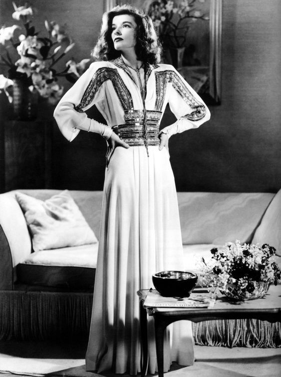 Katharine Hepburn wearing a long, cream dress designed by Adrian