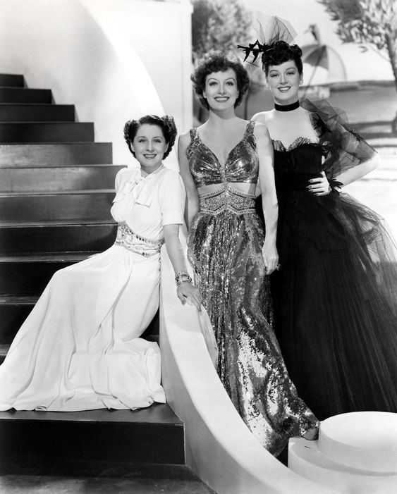 Norma Shearer, Joan Crawford, and Rosalind Russell posting in costumes in a publicity photo for The Women