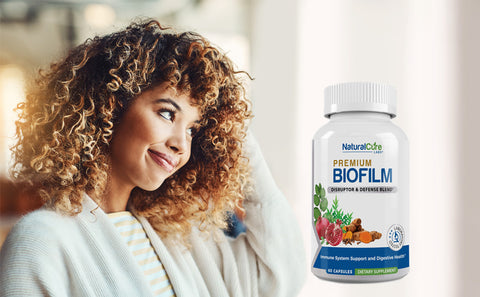A smiling woman looking at a bottle of "Premium Biofilm Immune Support Complex" supplements, indicating the product's use as a biofilm disruptor to boost the immune system.