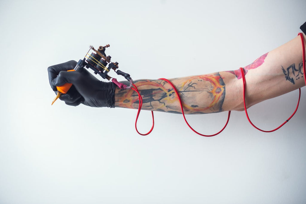 a man holding a tattoo gun infection lymph nodes tattoos science practice destroy macrophages antibodies stress ink ink break university macrophages alabama science researchers antibodies macrophages macrophages tattoos
