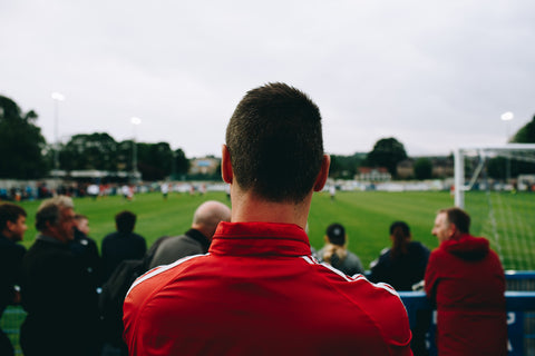 a man standing while watching soccer
